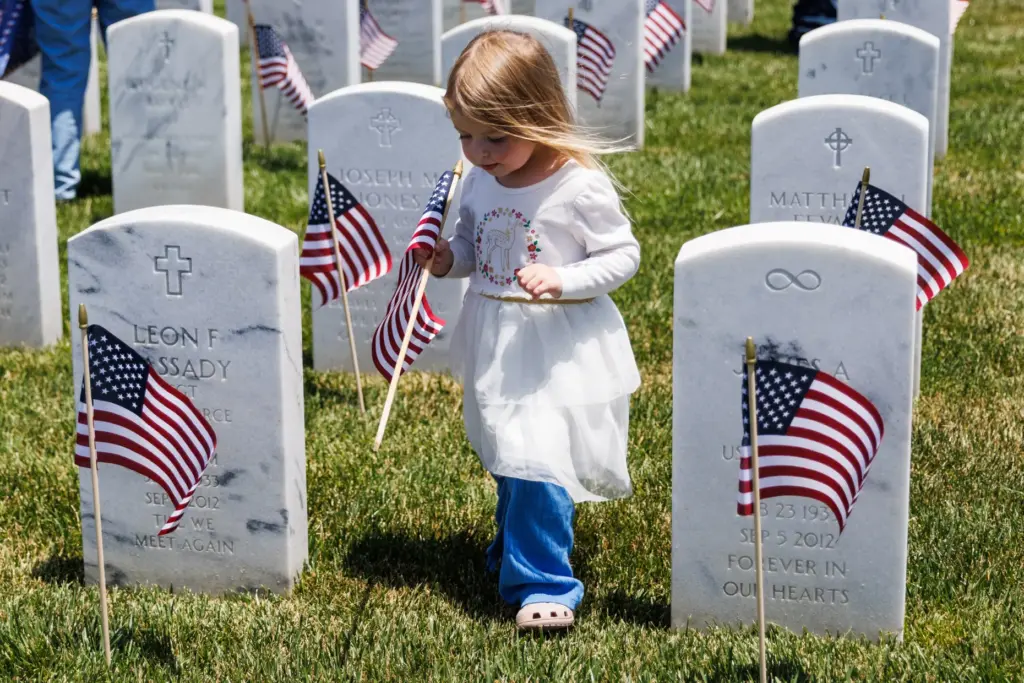 Aubrey Sanford, 3, holds a U.S. flag as she walks...
