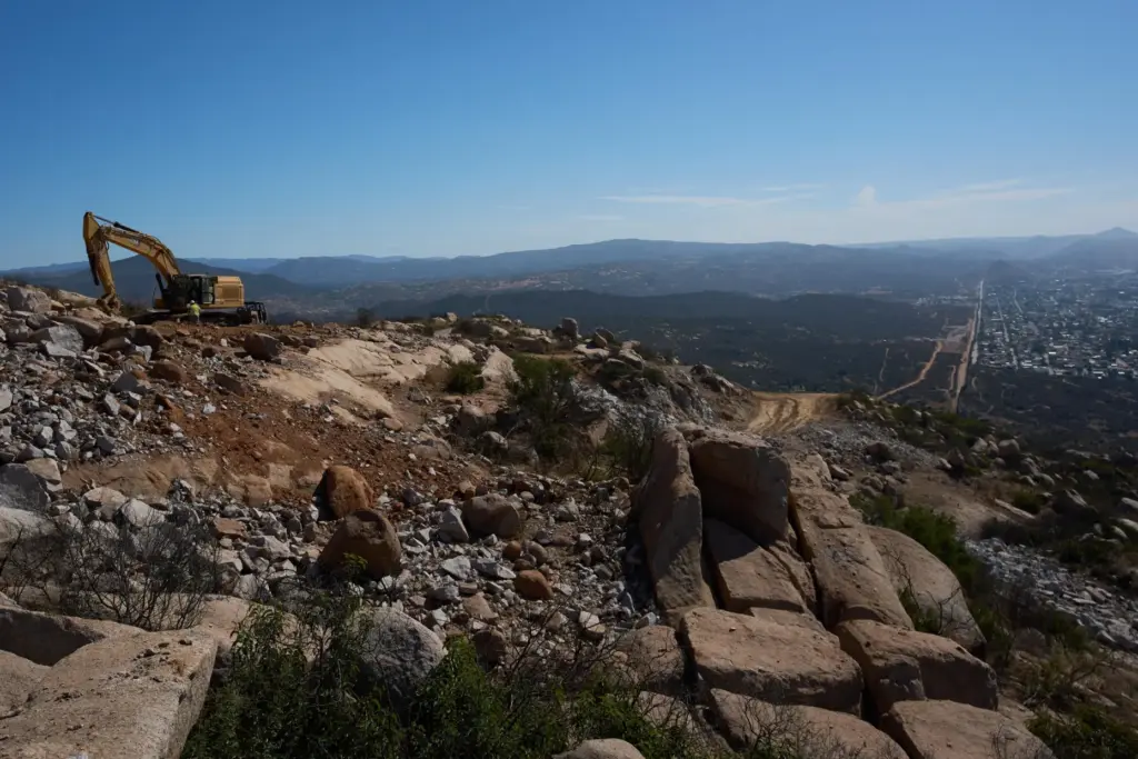 Construction crews work on a new border wall segment