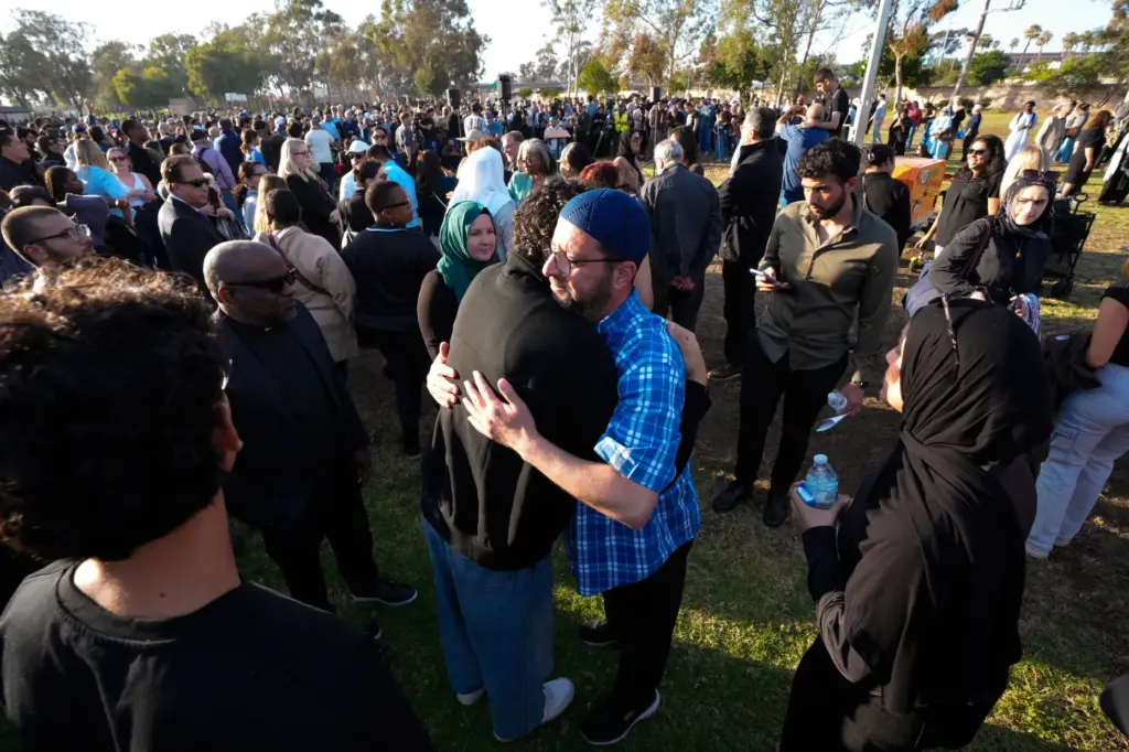 Taha Hassane, the centerâs imam is met with people who...