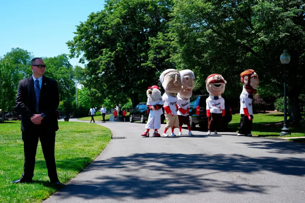Mascots of the Washington Nationals baseball team stand near the south lawn of the White House