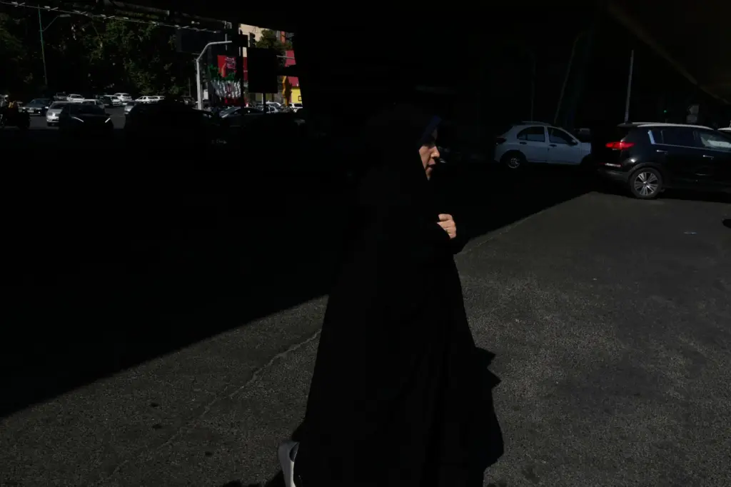 A woman crosses an intersection in northern Tehran.