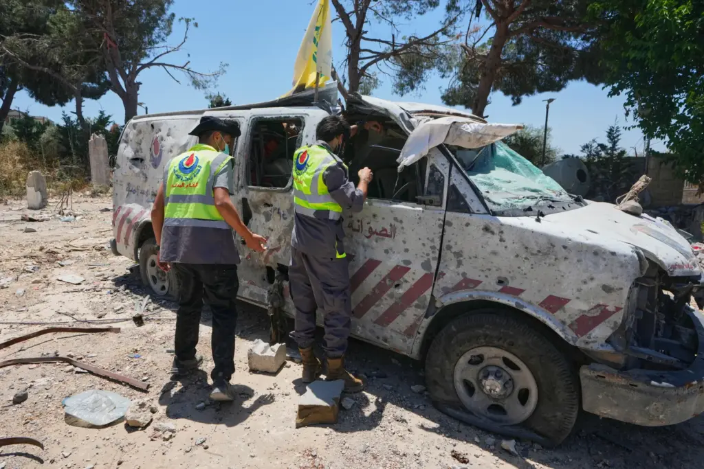 Rescue workers inspect a damaged ambulance belonging to Hezbollah's health unit.