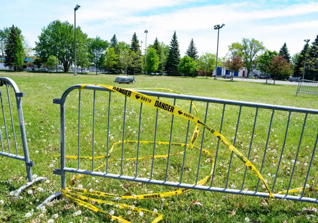 Warning tape is wrapped around barriers in Parc Ouellette in...