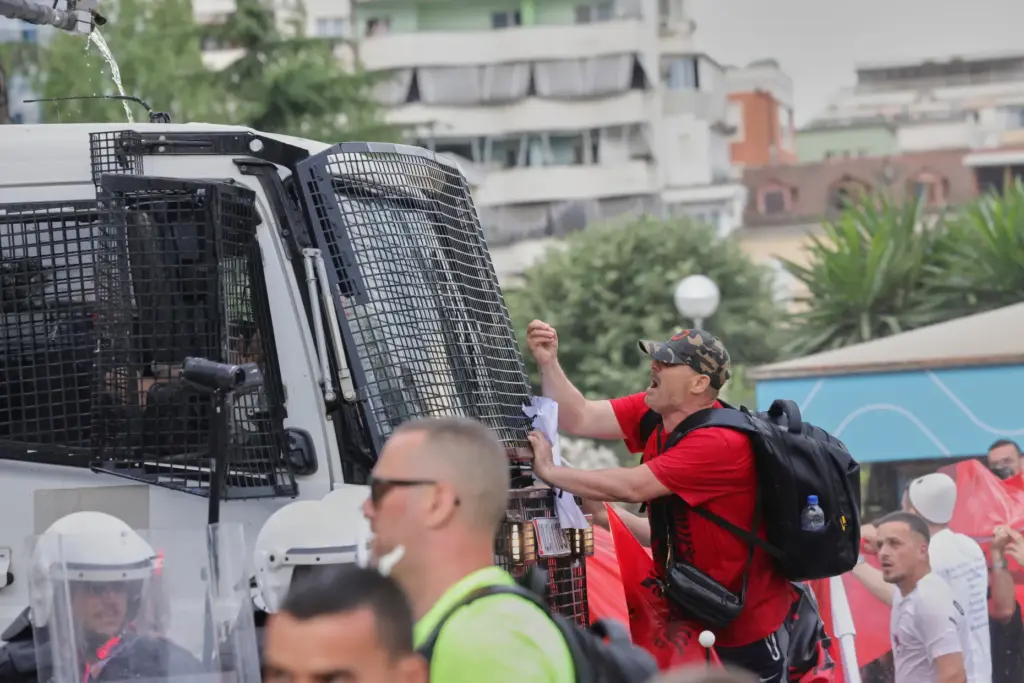 A protester argues with police officers in a water cannon...