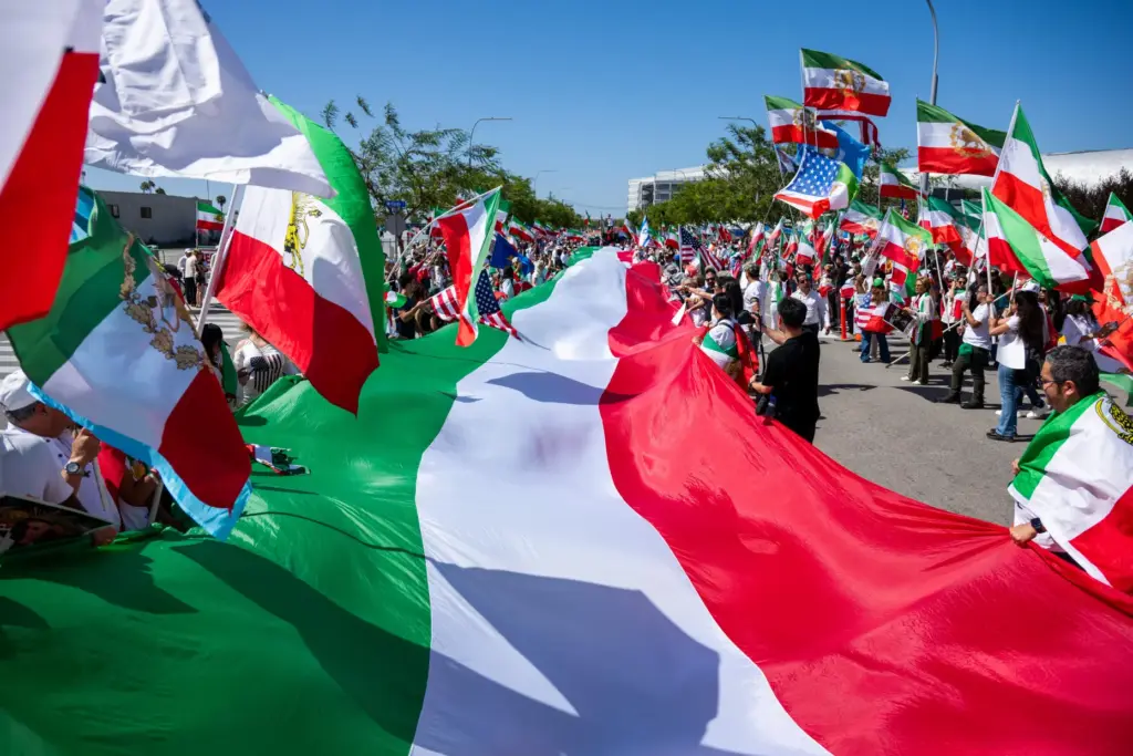 People carry a giant Iranian flag during a protest in...