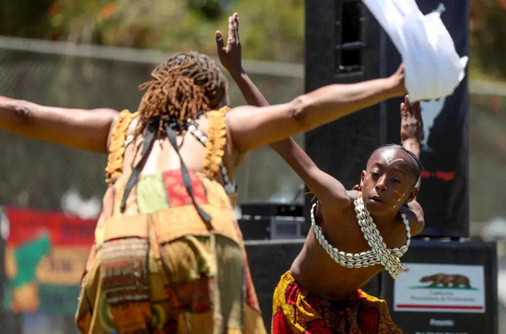 Sydney Antoine, 10, dances with Sadie Lee, instructor for the...