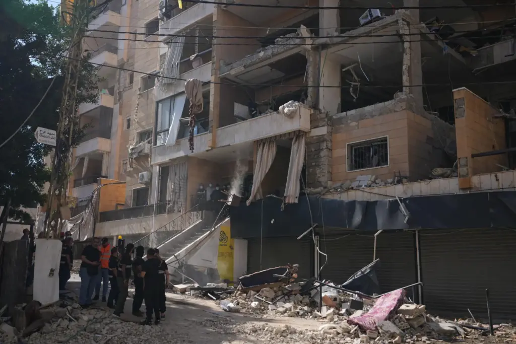 Lebanese security officers gather at the site where an Israeli airstrike hit a building.