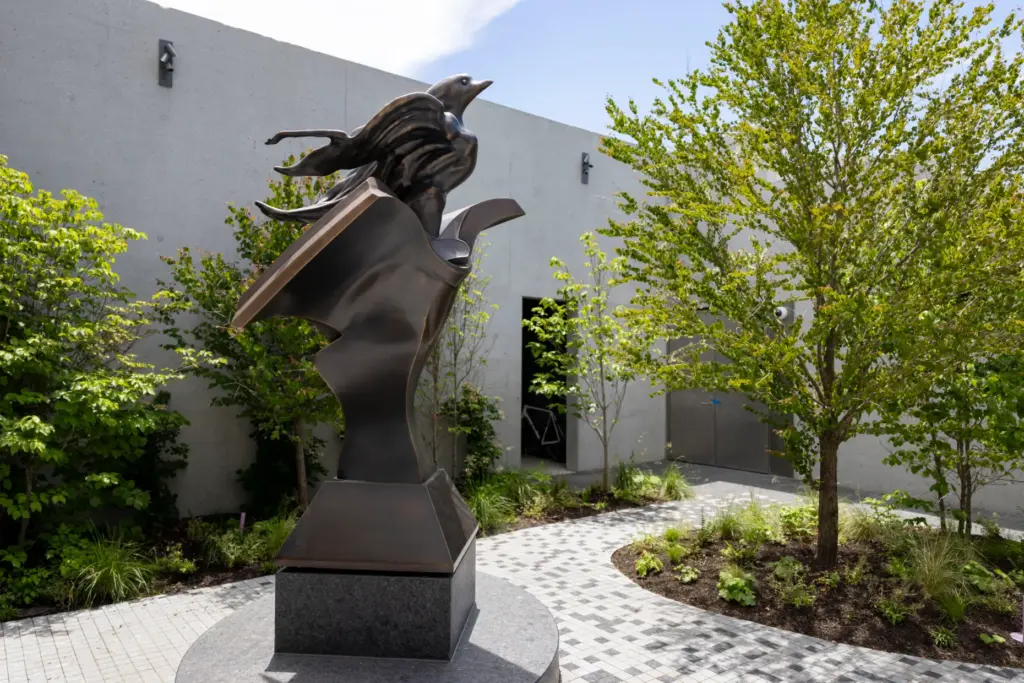 A statue by Richard Hunt sits in a courtyard outside...