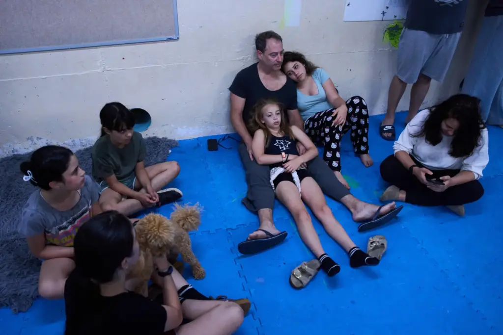 People take shelter as air raid sirens warn of incoming Iranian missiles in Ramat Gan, Israel.