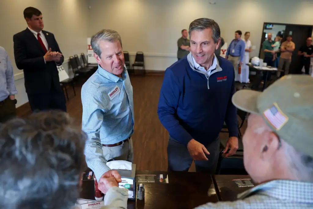 FILE – Gov. Brian Kemp, center left, and Republican U.S....