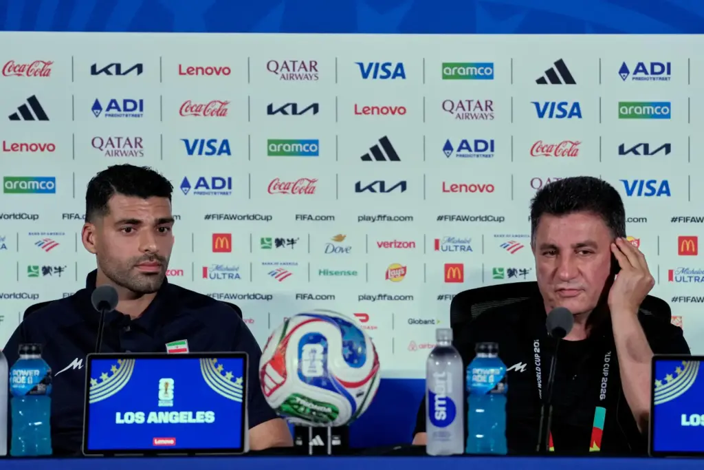 Iran head coach Amir Ghalehnoy, right, and player Mehdi Taremi...