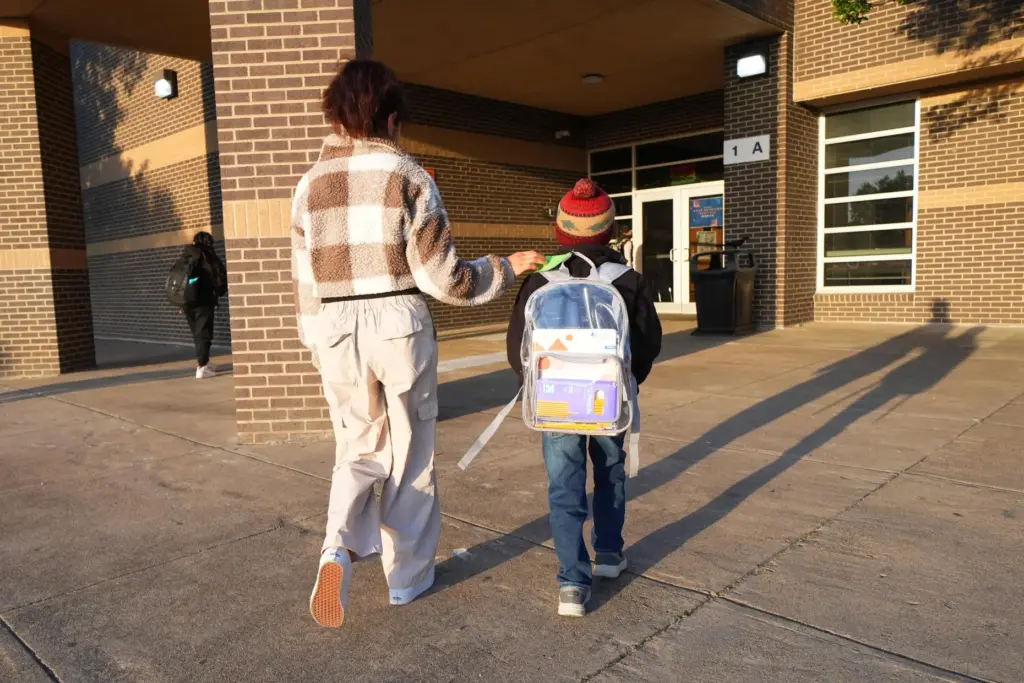 Maria Contreras, left, walks her son, Ian Contreras, to school...