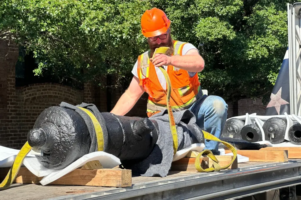 Bradford Shields fastens lifting straps to a cannon, which sunk...
