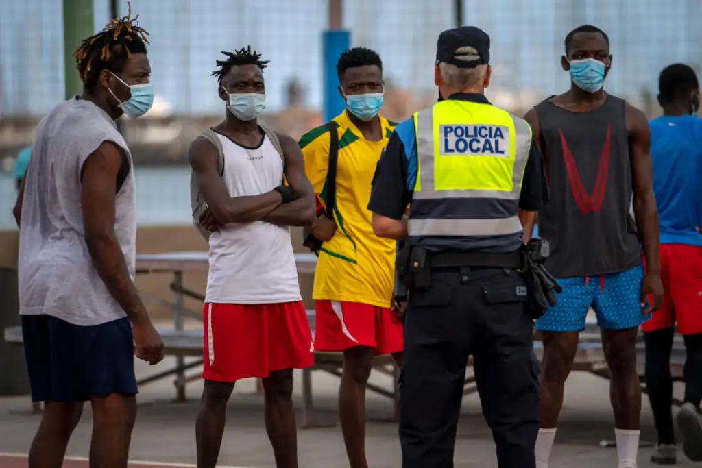 A police officer speaks with migrants and asylum-seekers in Gran Canaria island.