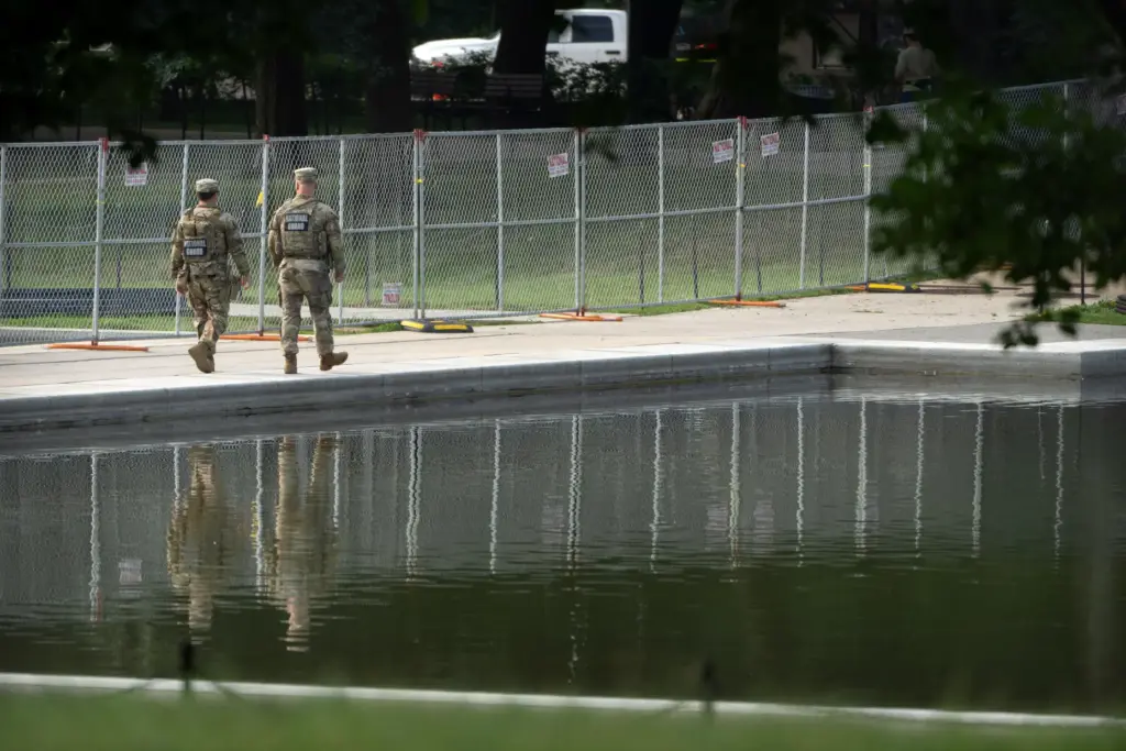 National Guard members walk near the Lincoln Memorial Reflecting Pool,...