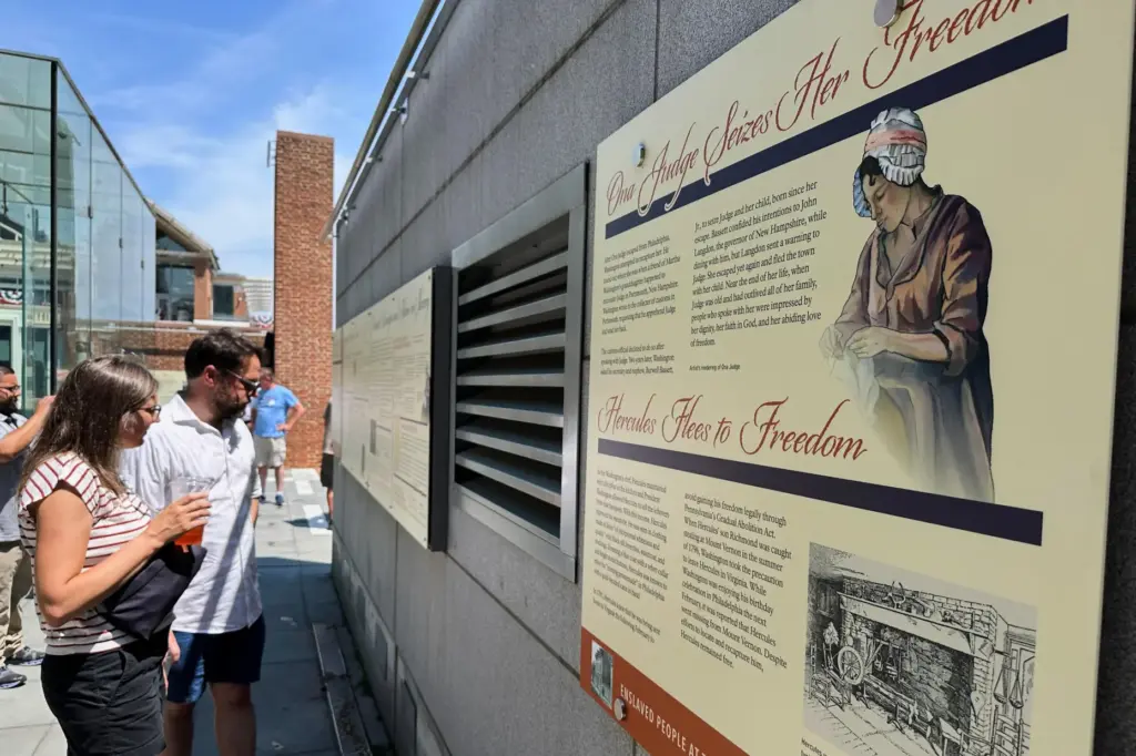Visitors view the reinstalled educational panels about slavery at the...