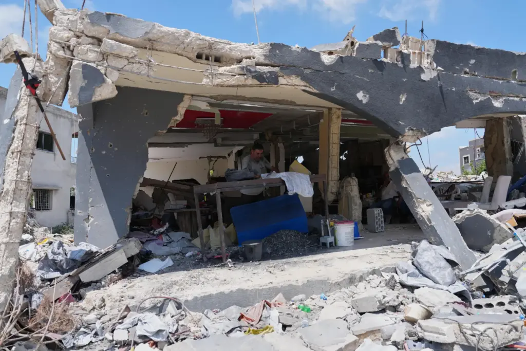 A resident works inside his shop, which was heavily damaged...
