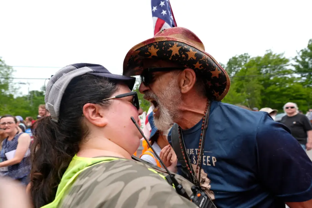 A counter protester yells at a volunteer providing security during...