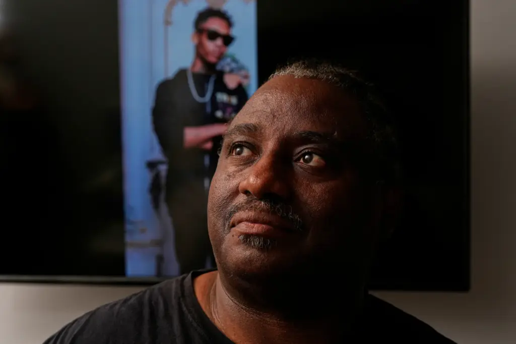Evaniel Johnson poses with a picture of his grandson, Tyrin...