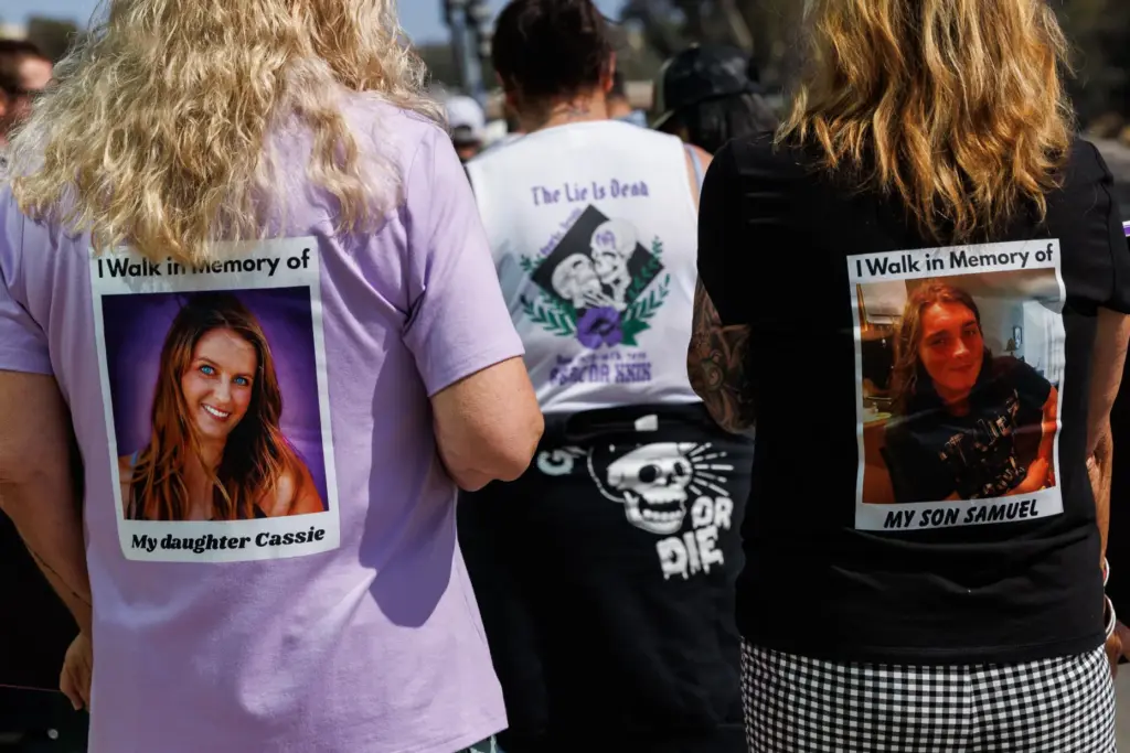 Caroline Walker and Cindy Parente wear shirts of their children,...