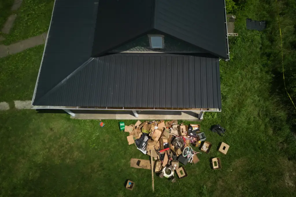 Debris is strewn on the front lawn of a home...