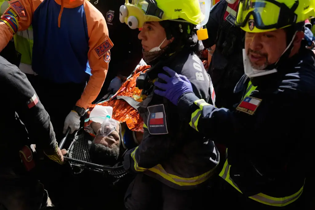 Chilean rescue workers carry Hernán Alberto Gil Flores after he...