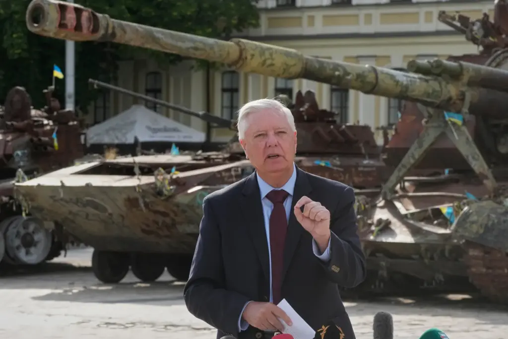 Sen. Lindsey Graham answer media questions near a damaged Russian tanks exhibition.