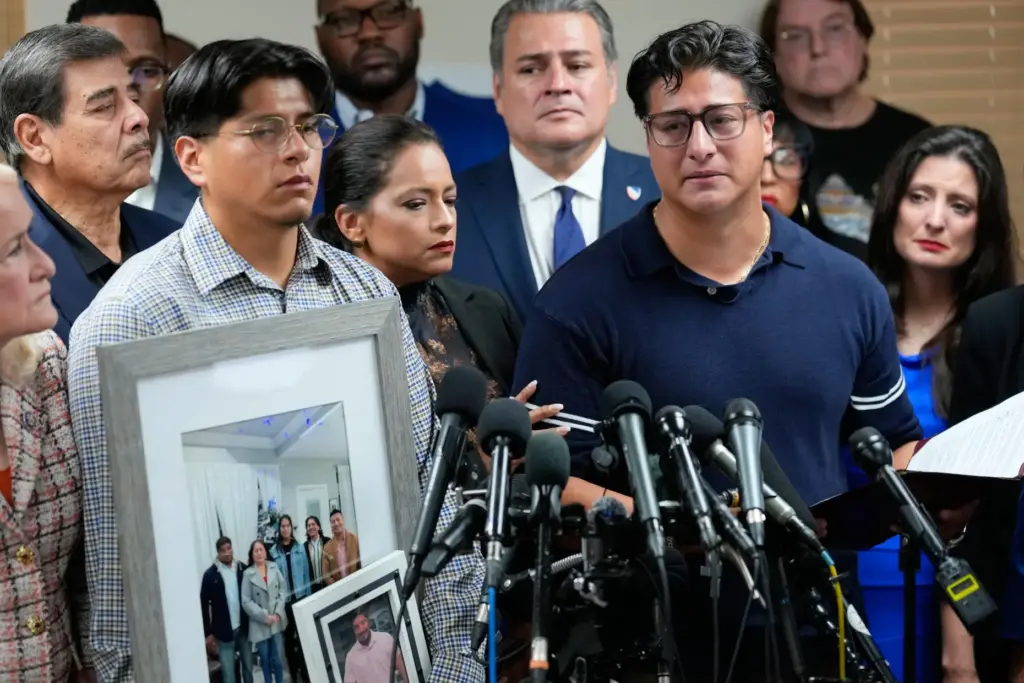 Ronaldo Salgado, right, son of Lorenzo Salgado Araujo, speaks as...