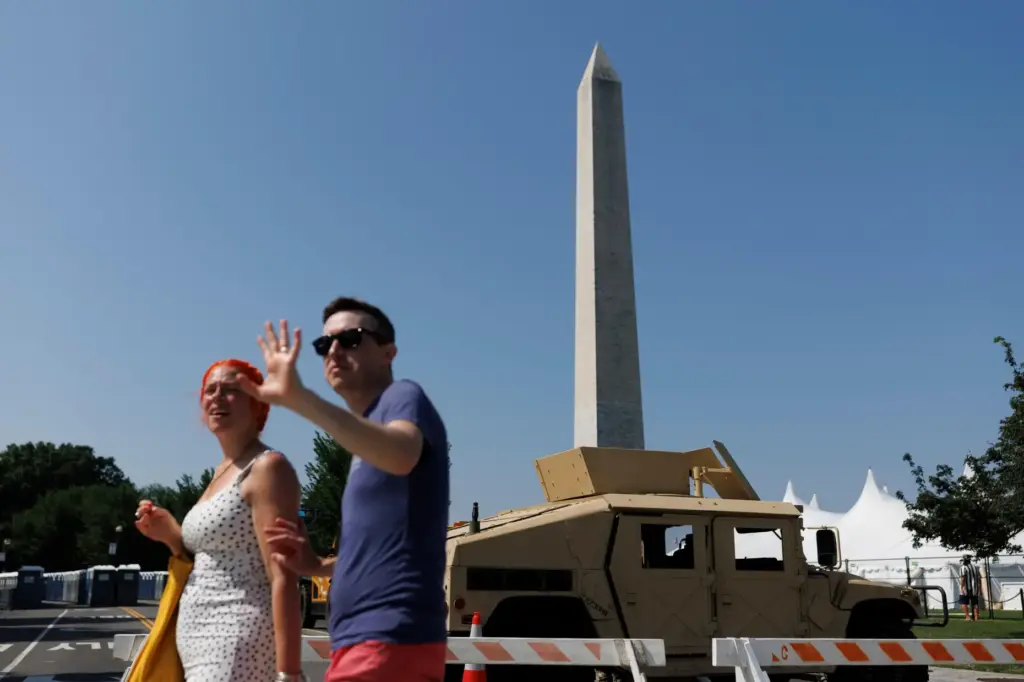 People cross 15th Street Northwest as a National Guard Humvee...
