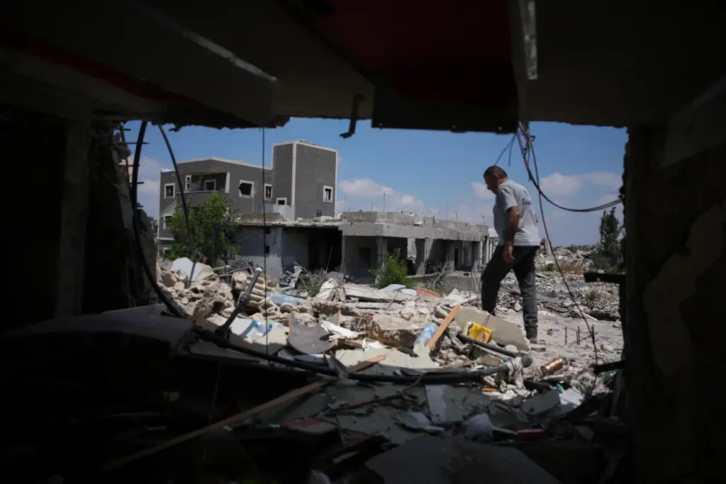 A resident inspects the damage to his home, destroyed in...