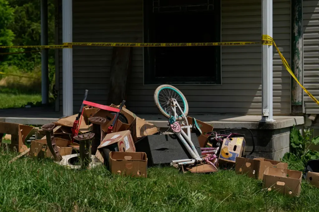 Police tape and debris are seen at a home where...