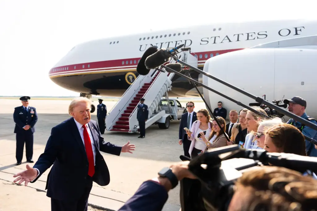President Donald Trump speaks with reporters before boarding the new...
