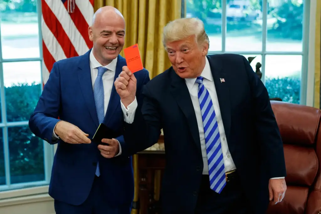 FILE – President Donald Trump holds up a red card...