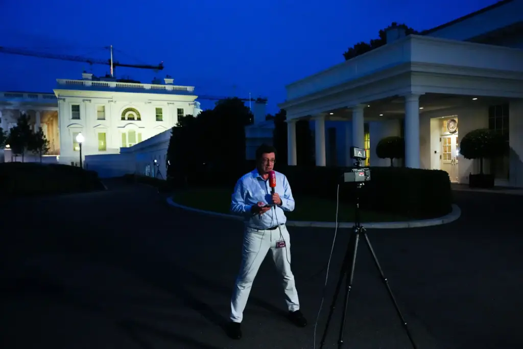 A reporter from Buro, a Russian-language YouTube channel, films in front of the White House.