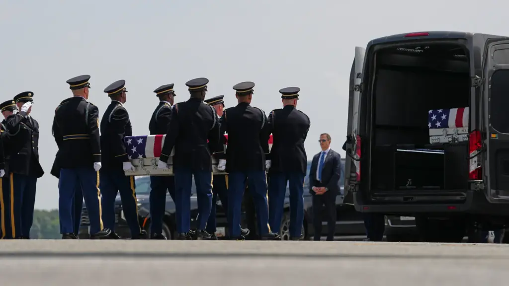 A U.S. Army carry team moves a transfer case containing...