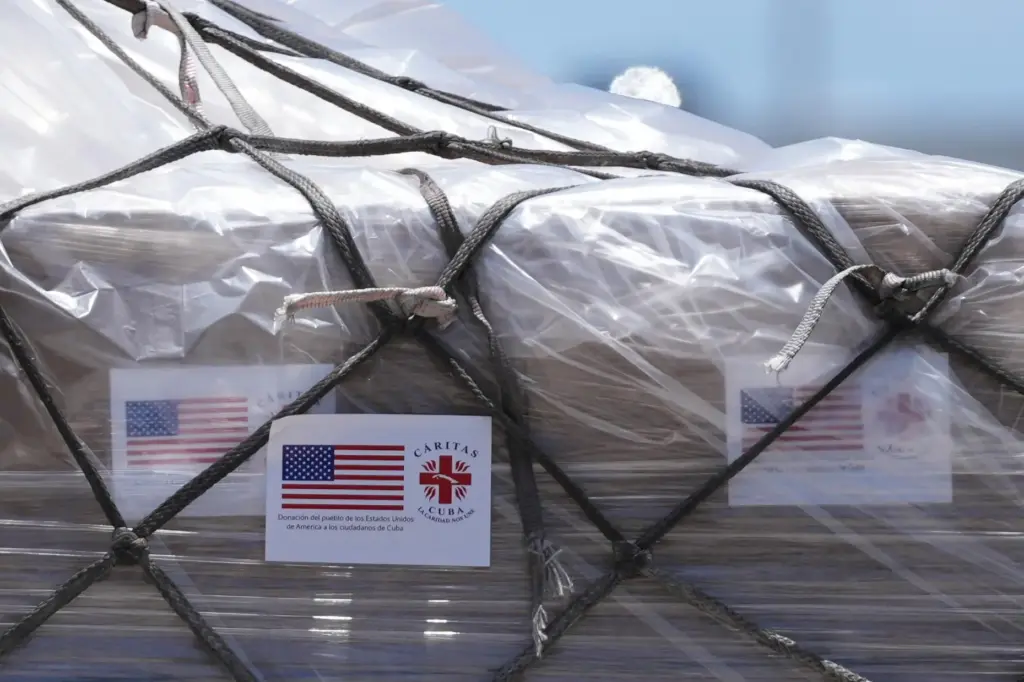 People load pallets containing food and hygiene kits for a...