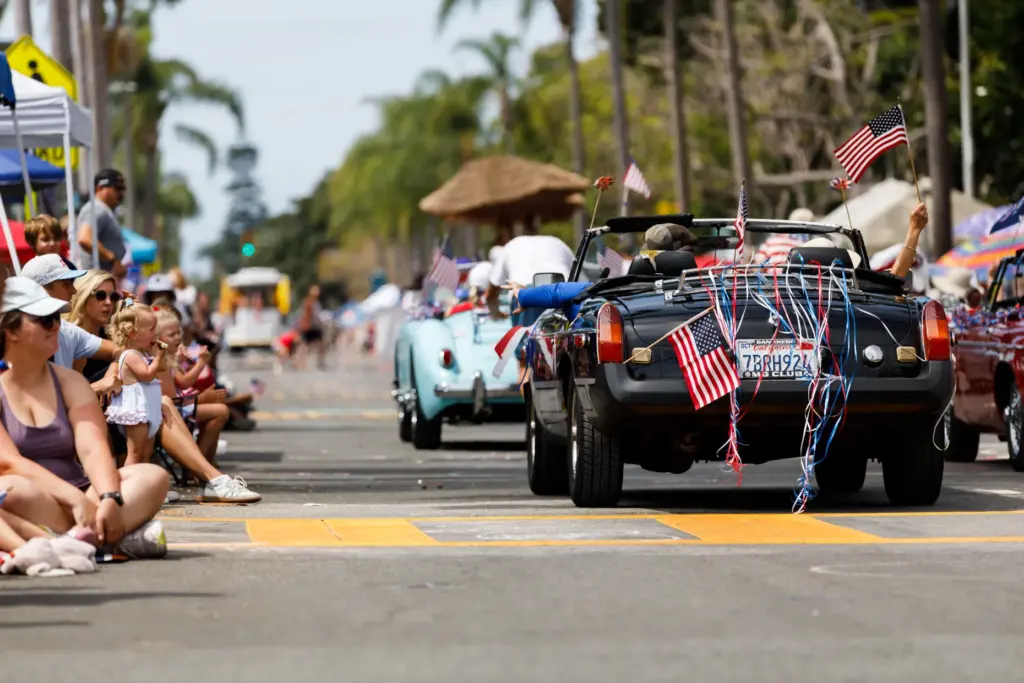 A classic MG vehicle is shown decorated with American flags....