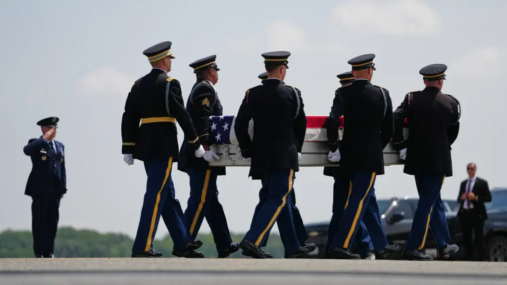 A U.S. Army carry team moves a transfer case containing...
