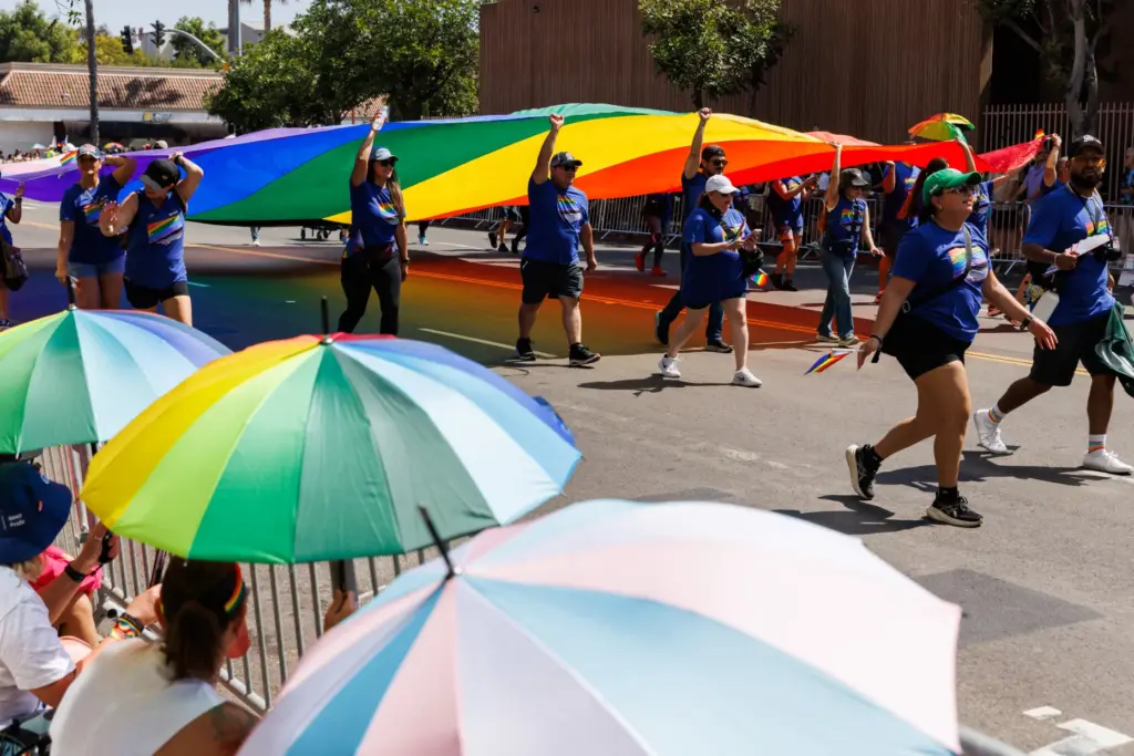 Participants with US Bank carry a pride flag down Sixth...