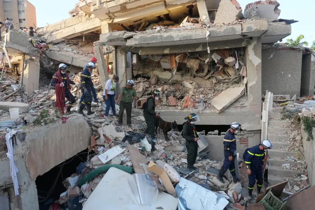 Vietnamese rescuers searches a building that collapsed during back-to-back earthquakes...