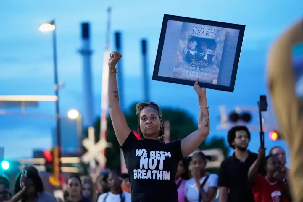 A protester holds a photo of Corey Durell Ruiz as...