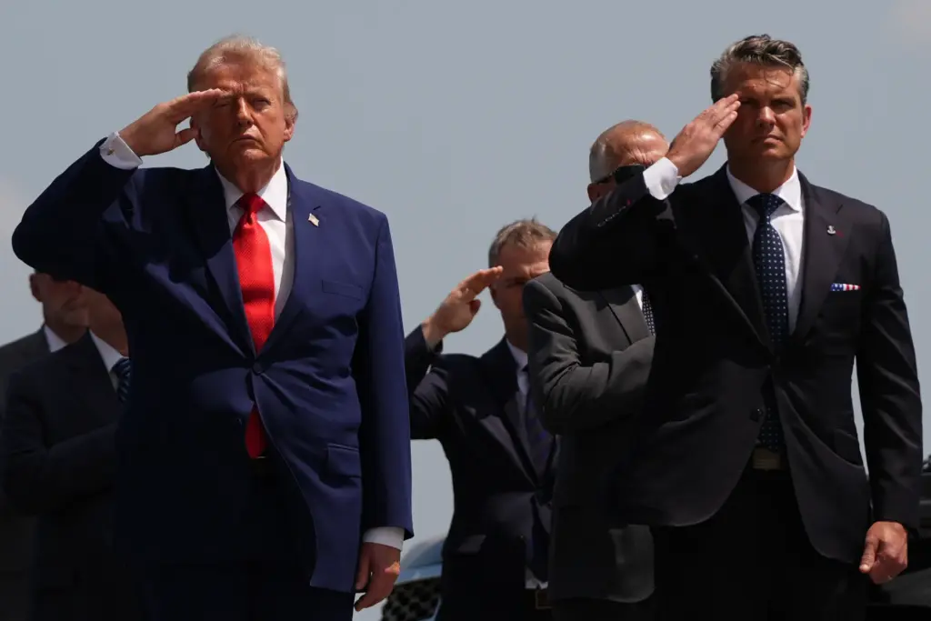 President Donald Trump and Defense Secretary Pete Hegseth salute as...