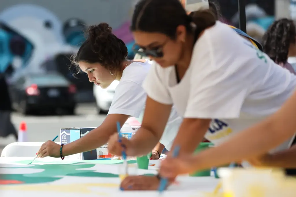 Julliette PeÃ±aloza paints on a mural Saturday with other community...