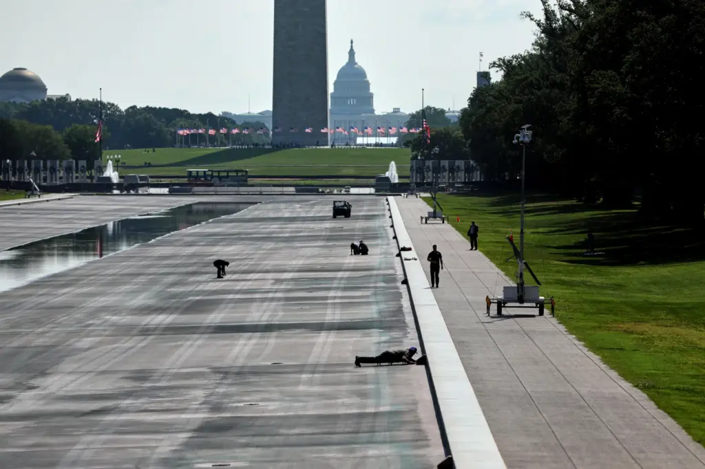 National Park Service workers work at the Lincoln Memorial Reflecting...