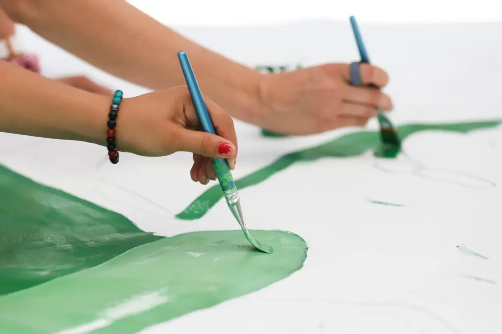 People paint on a mural in Logan Heights on Saturday....