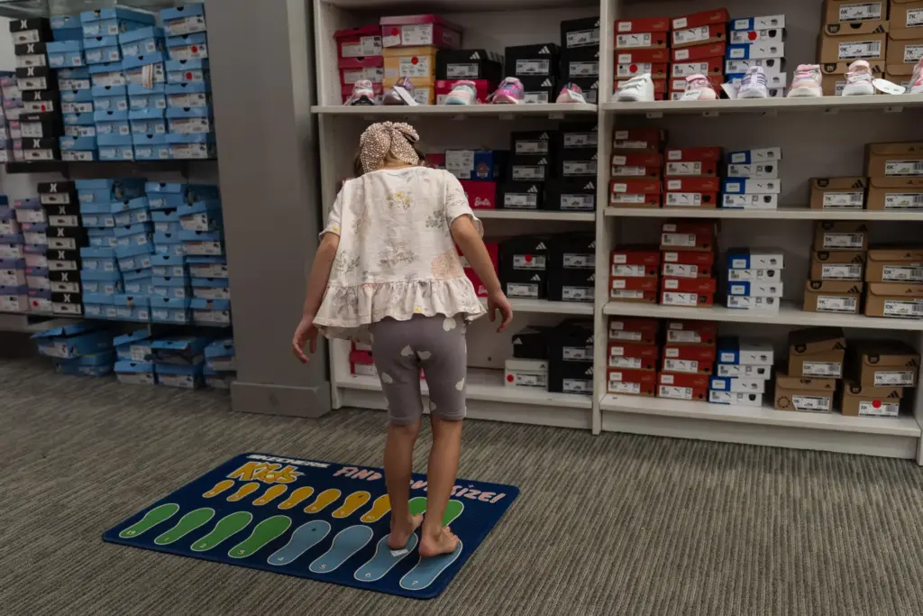 Lola Lialina stands on a foot-measuring mat while shopping for...