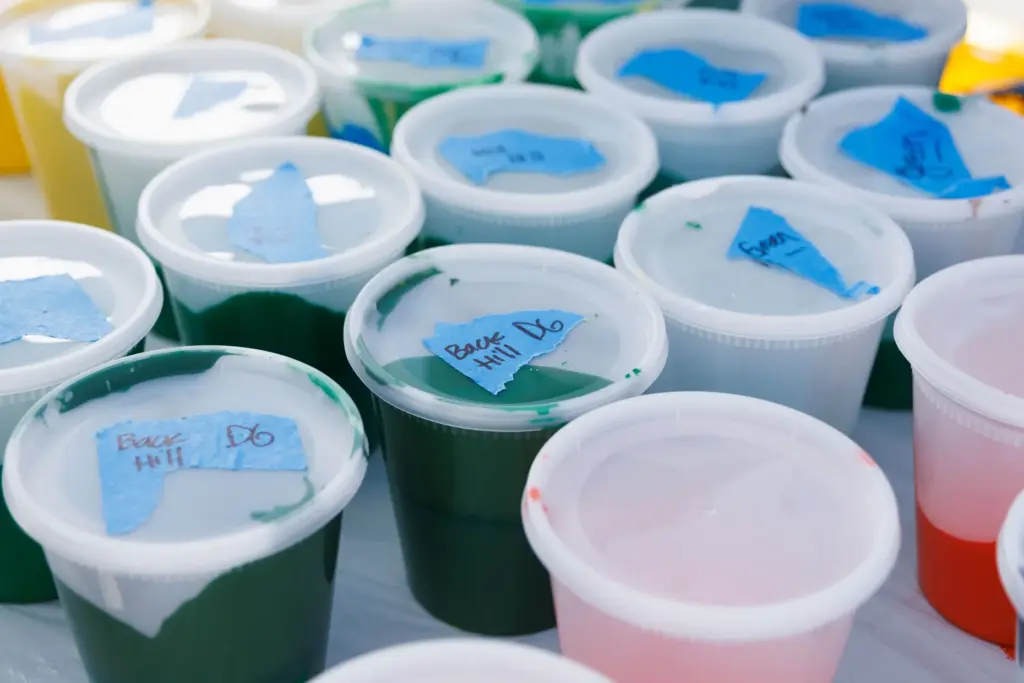 Containers filled with paint sit on a table Saturday to...