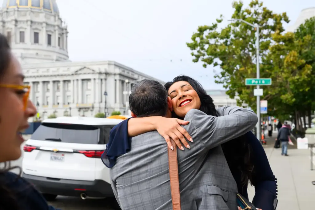 Plaintiff Clarissa Cervantes hugs a legal team member before attending...