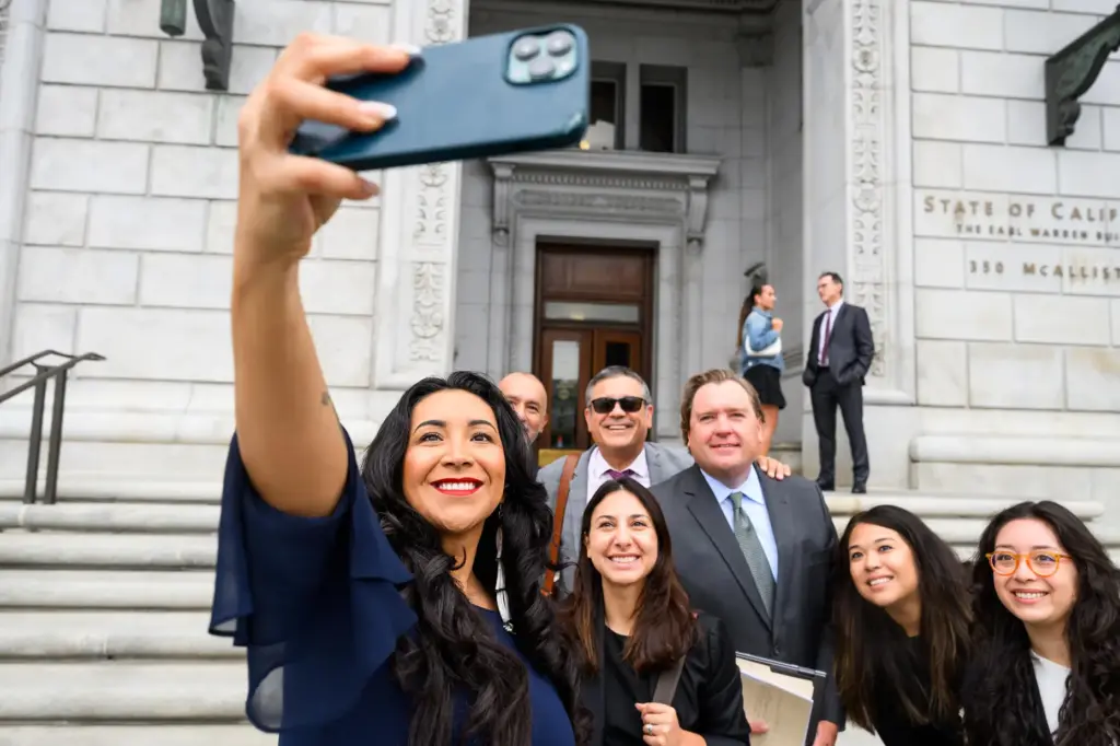 Plaintiff Clarissa Cervantes takes a selfie with legal team members...