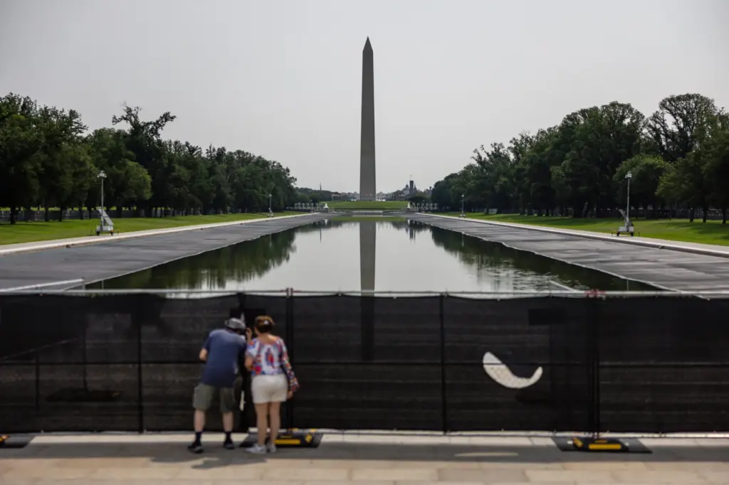 Visitors look at the drained Lincoln Memorial Reflecting Pool, Wednesday,...